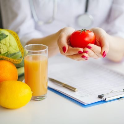 Conceptual Photo Of A Female Nutritionist With Fruits On The Desk.